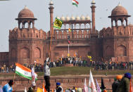 NEW DELHI, INDIA - JANUARY 26: Nishan Sahib or Sikh religious flags hoisted near the Indian tricolour at Red Fort during the farmers' tractor rally on Republic Day, on January 26, 2021 in New Delhi, India. A large number of protesters deviated from the designated route for the proposed tractor parade in the national capital and barged into the Red Fort. They were later removed by the police. (Photo by Sanjeev Verma/Hindustan Times via Getty Images)