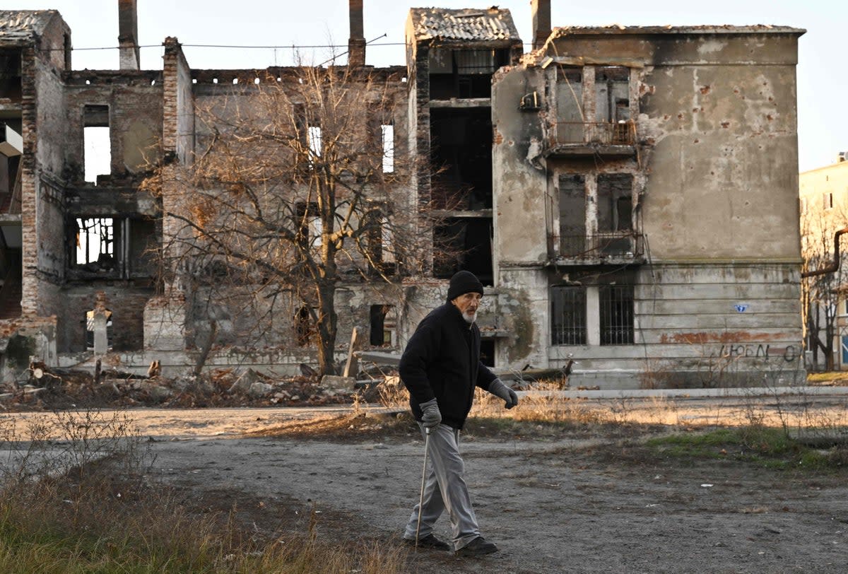 A local resident walks in front of a destroyed building in the town of Lyman on Wednesday  (AFP via Getty Images)