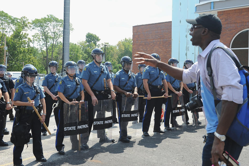 Ferguson resident Tirezz Walker speaks to Missouri Highway Patrol offers in riot gear outside the Ferguson Police Department on Aug.&nbsp;11, 2014.&nbsp;