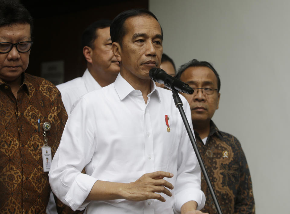 Indonesian President Joko Widodo, center, speaks to journalists after visiting Coordinating Minister for Politics, Law and Security Wiranto who was wounded in a knife attack, at a hospital in Jakarta, Indonesia, Thursday, Oct. 10, 2019. A knife-wielding man, who may have been radicalized by the Islamic State group's extremist ideology, wounded the top security minister, a local police chief and another person in a western province on Thursday, police said. (AP Photo/Achmad Ibrahim)