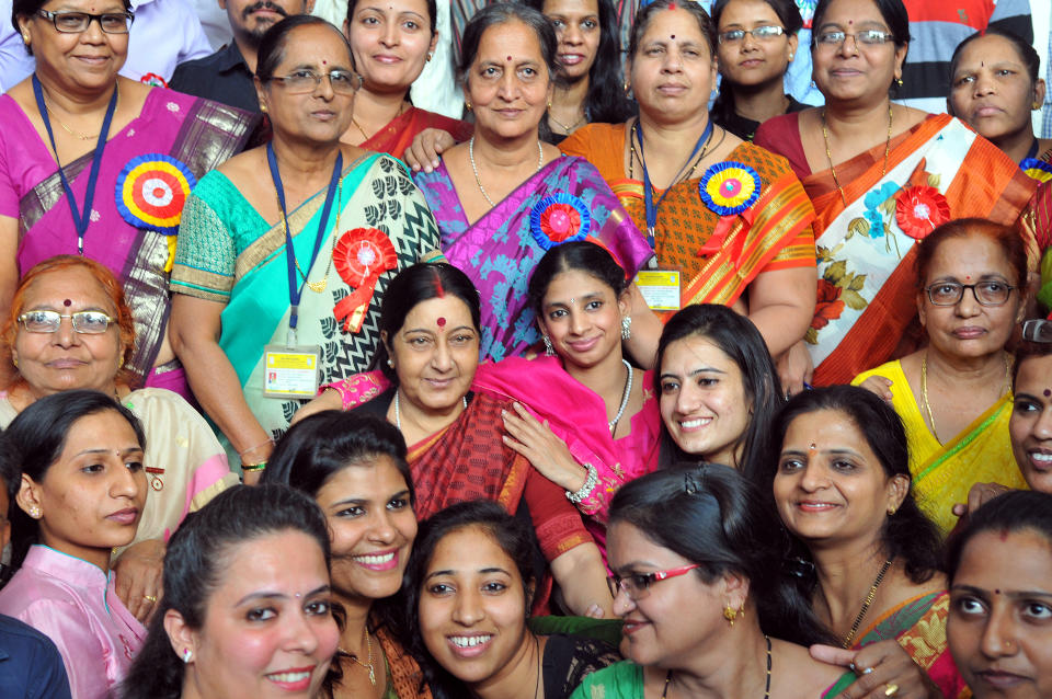 Sushma Swaraj and Geeta pose for pictures with their friends and faculty at Indore Deaf Bilingual Academy (IDBA) on November 23, 2015. (Photo by Shankar Mourya/Hindustan Times via Getty Images)