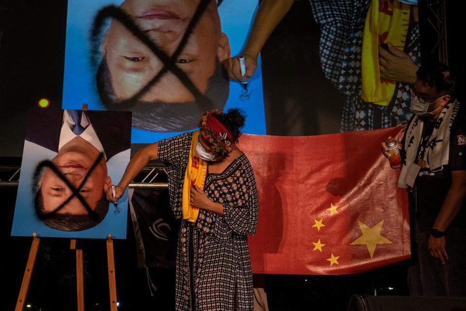 Demonstrators spray paint over an upside down portrait of Chinese leader Xi Jinping during an anti-China protest on October 1, 2021 in Taipei, Taiwan. China's National Day is celebrated over a one-week period, beginning from October 1 and running until October 7. The event is usually met with protests in Taiwan and takes on a special significance this year as tensions rise in the region.