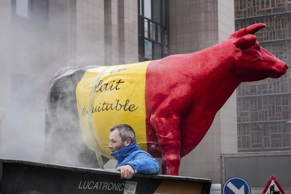 European dairy farmers spray the EU Council building with milk powder to protest the crisis in their sector, in Brussels on Monday, Jan. 23, 2017. The sector has been hit with sagging prices and production costs squeezing profits to the extent that has driven many farmers to the brink of bankruptcy. The EU's executive Commission has approved some support measures over the past year, but the farmers fear that releasing more milk powder on the market would further complicate their plight. (AP Photo/Geert Vanden Wijngaert)