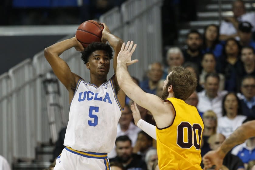 UCLA guard Chris Smith (5) passes against Arizona State forward Mickey Mitchell.