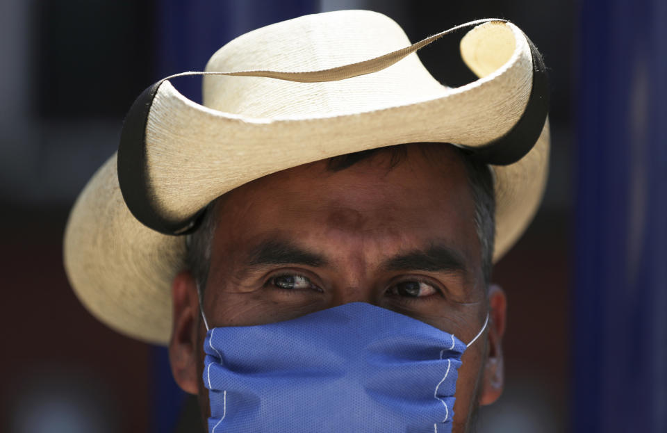 A street vendor wears a mask over his mouth as a precaution against the spread of the new coronavirus in Mexico City, Friday, Feb. 28, 2020. Mexico's assistant health secretary announced Friday that the country now has confirmed cases of the COVID-19 virus. (AP Photo/Fernando Llano)