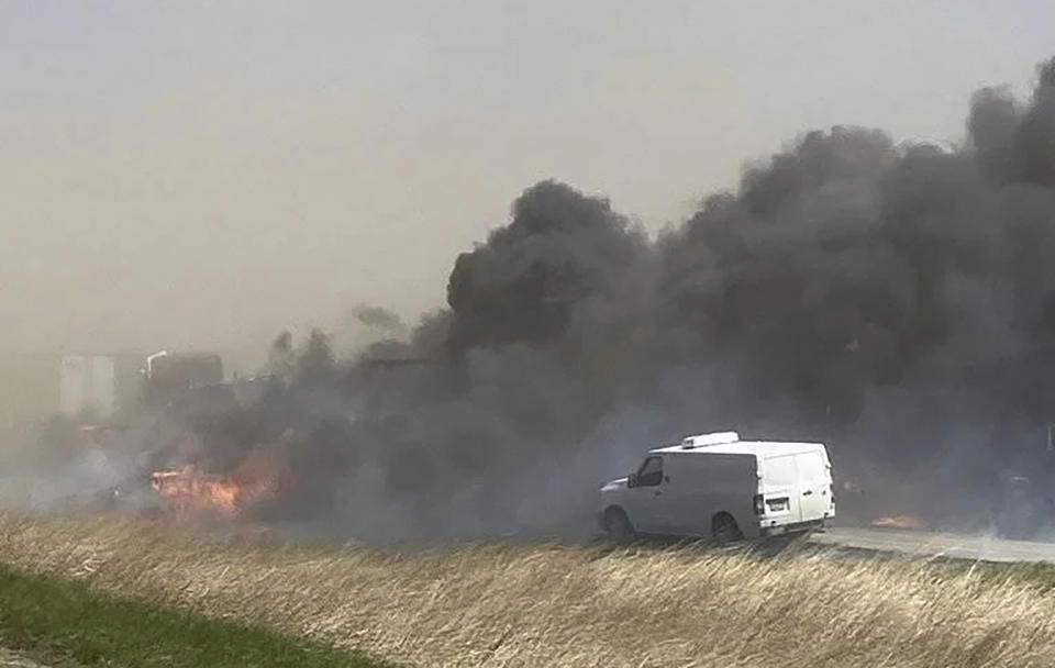 Smoke billows after a crash involving at least 20 vehicles shut down a highway in Illinois, Monday, May 1, 2023. Illinois State Police say a windstorm that kicked up clouds of dust in south-central Illinois led to numerous crashes and multiple fatalities on Interstate 55. (WICS TV via AP)