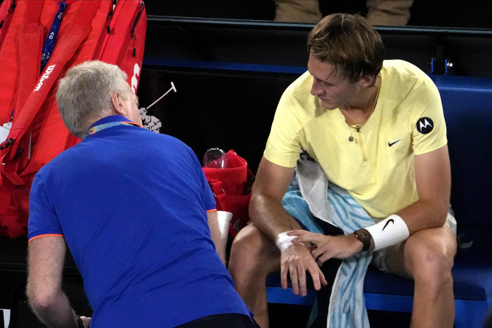 Sebastian Korda of the U.S. talks with medical staff after having his wrist taped during his quarterfinal match against Karen Khachanov of Russia at the Australian Open tennis championship in Melbourne, Australia, Tuesday, Jan. 24, 2023. (AP Photo/Ng Han Guan)