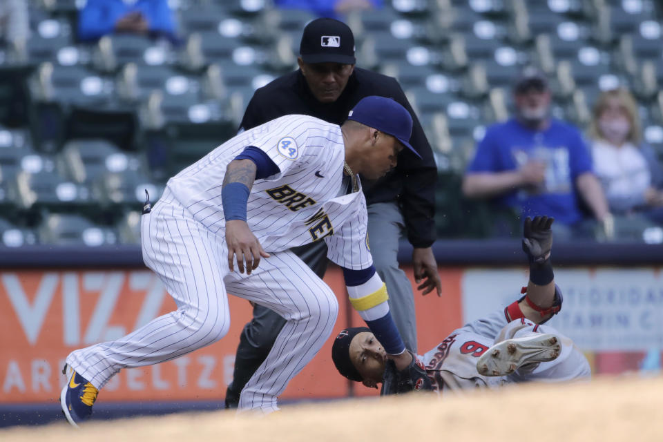 Minnesota Twins' Andrelton Simmons (9) slides in safely at third base past the tag of Milwaukee Brewers' Orlando Arcia during the eighth inning of a baseball game Sunday, April 4, 2021, in Milwaukee. (AP Photo/Aaron Gash)