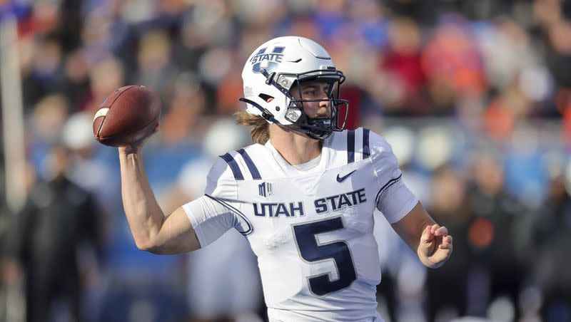 Utah State quarterback Cooper Legas (5) looks downfield against Boise State in the first half of an NCAA college football game, Friday, Nov. 25, 2022, in Boise, Idaho. Boise State won 42-23. Legas came in reserve against UConn and helped the Aggies come back from a 17-0 deficit.