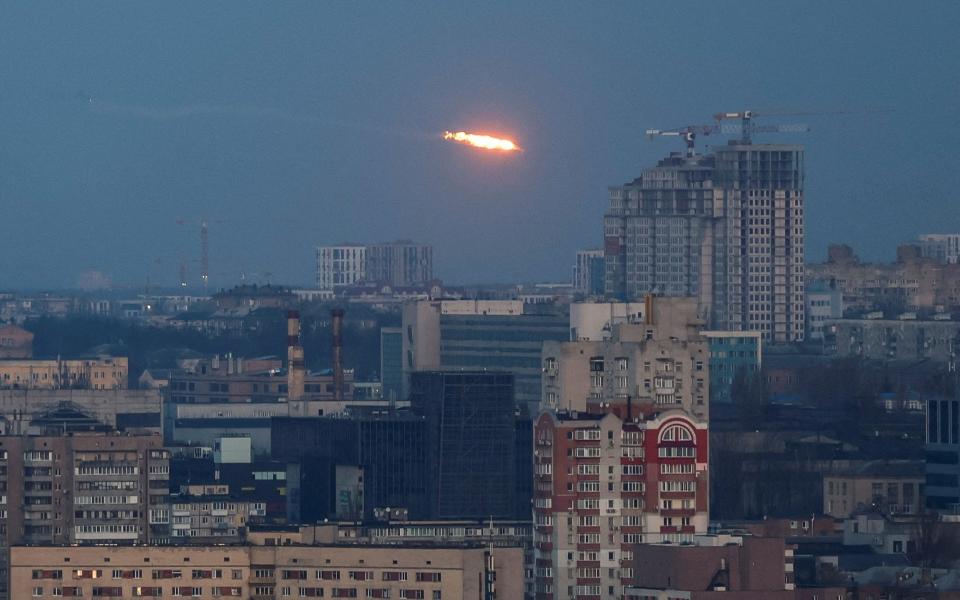 An explosion of a missile is seen in the sky over Kyiv