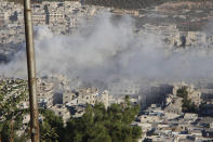 This photo provided by the Syrian Civil Defense White Helmets, which has been authenticated based on its contents and other AP reporting, shows smoke rising from Syrian government shelling on the northern town of Ariha, in Idlib province, Syria, Wednesday, Oct. 20, 2021. Rescue workers reported several people were killed, including children and a woman, in the shelling of Ariha, a town in the last rebel enclave in the country's northwest. (Syrian Civil Defense White Helmets via AP)