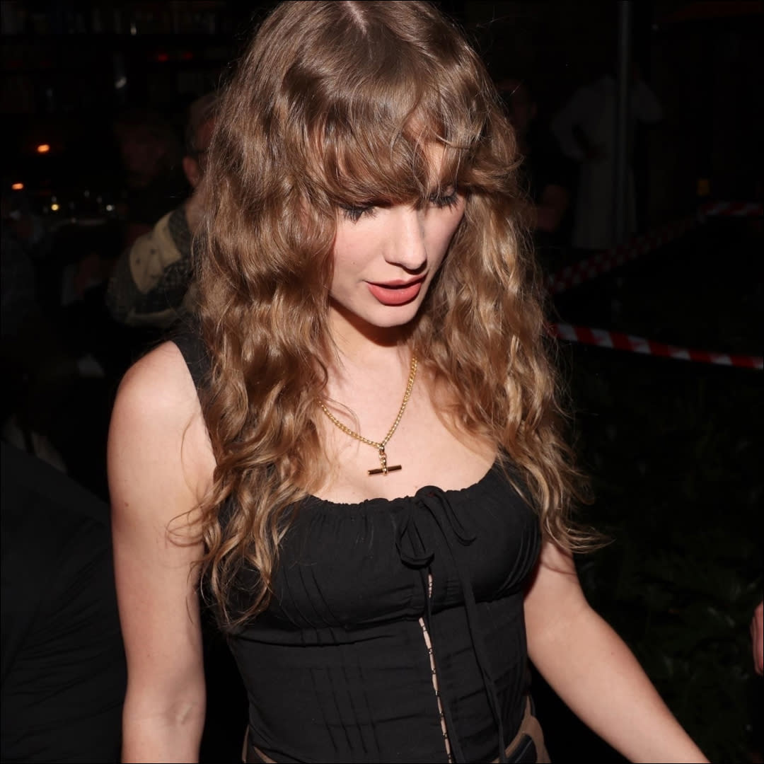  Taylor Swift in Australia wearing a black top and gold necklace. 