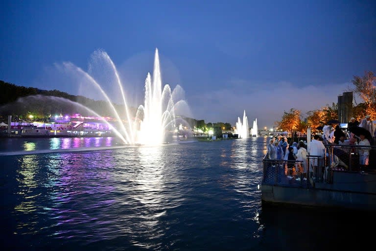 Los espectadores ven un espectáculo de luz y agua desde las orillas del río Sena