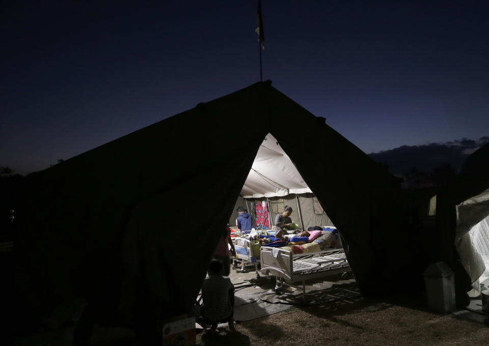 In this Tuesday, Aug. 7, 2018, photo, villagers injured in an earthquake are tended to inside a makeshift hospital in Tanjung, North Lombok, Indonesia. (AP Photo/Tatan Syuflana)