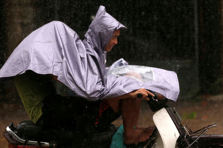 People ride a motorbike while the Doksuri storm hits in Ha Tinh province, Vietnam September 15, 2017. REUTERS/Kham