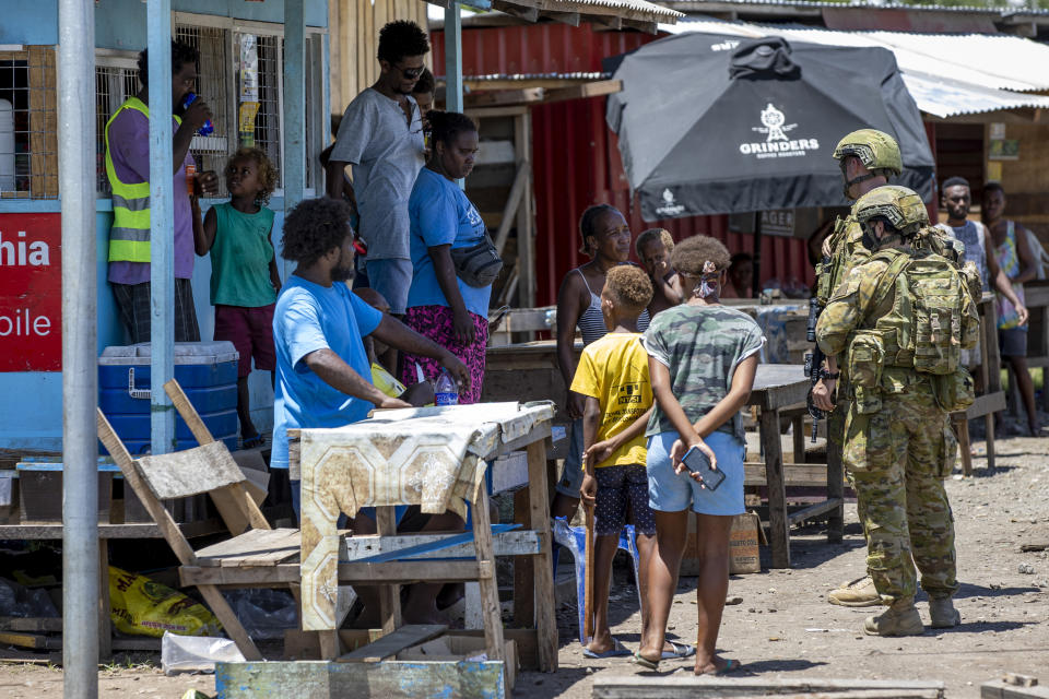 FILE - In this photo provided by the Department of Defence, Australian Army soldiers talk with local citizens during a community engagement patrol through Honiara, Solomon Islands, on Nov. 27, 2021. A leaked document indicates that China could boost its military presence in the Solomon Islands — including with ship visits — in a development that is raising alarm in nearby Australia and beyond. The Solomon Islands revealed on Thursday, March 24, 2022, it had signed a policing cooperation agreement with China. But more concerning to Australia was the draft text of a broader security arrangement that was leaked online. (Cpl. Brandon Grey/Department of Defence via AP, File)