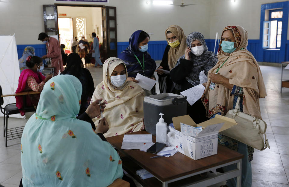 A teacher receives the first shot of the Sinovac coronavirus vaccine from a paramedic while in a vaccination center at a school in Lahore, Pakistan, Friday, May 28, 2021. (AP Photo/K.M. Chaudary)