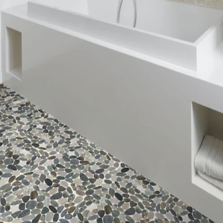 faux rocks tile floor next to bathtub
