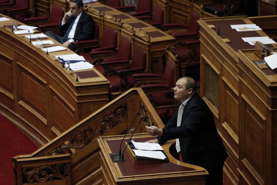 Golden Dawn lawmaker Georgios Germenis, one of five party lawmakers jailed pending trial for allegedly running a criminal organization, speaks during a parliament session in Athens, on Wednesday, May 7, 2014. Two jailed Greek lawmakers granted special prison leave have appeared in Parliament to defend themselves against charges linked with a judicial crackdown on the Nazi-inspired Golden Dawn party. (AP Photo/Petros Giannakouris)