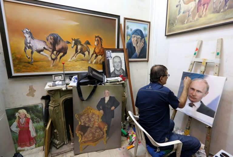 Iraqi artist Mohammed Karim Nihaya touches up a painting of Russian President Vladimir Putin in his studio in the Karada district of Baghdad on October 7, 2015