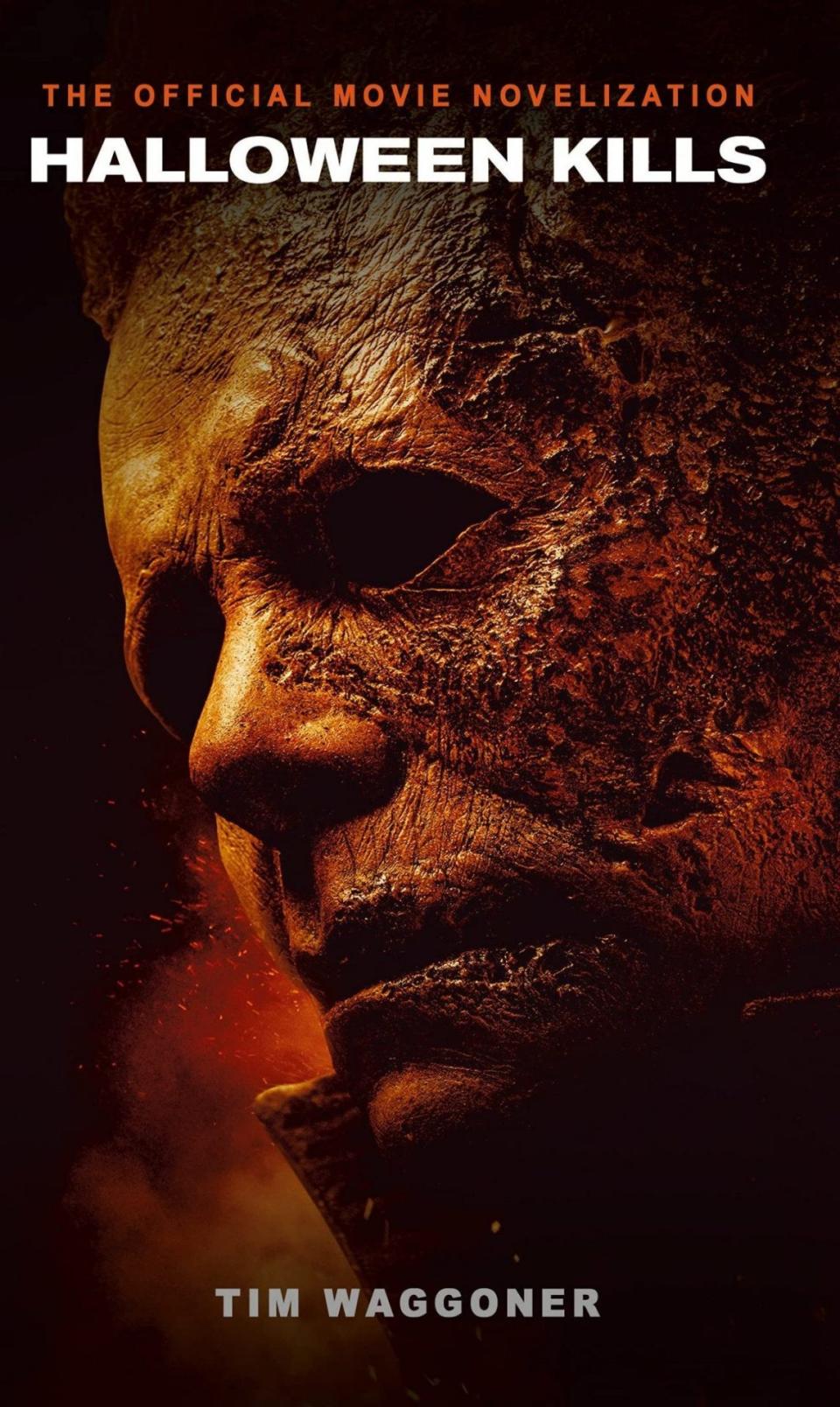 Halloween Kills official novel cover featuring Michael Myers with half burned mask in a orangish red tint