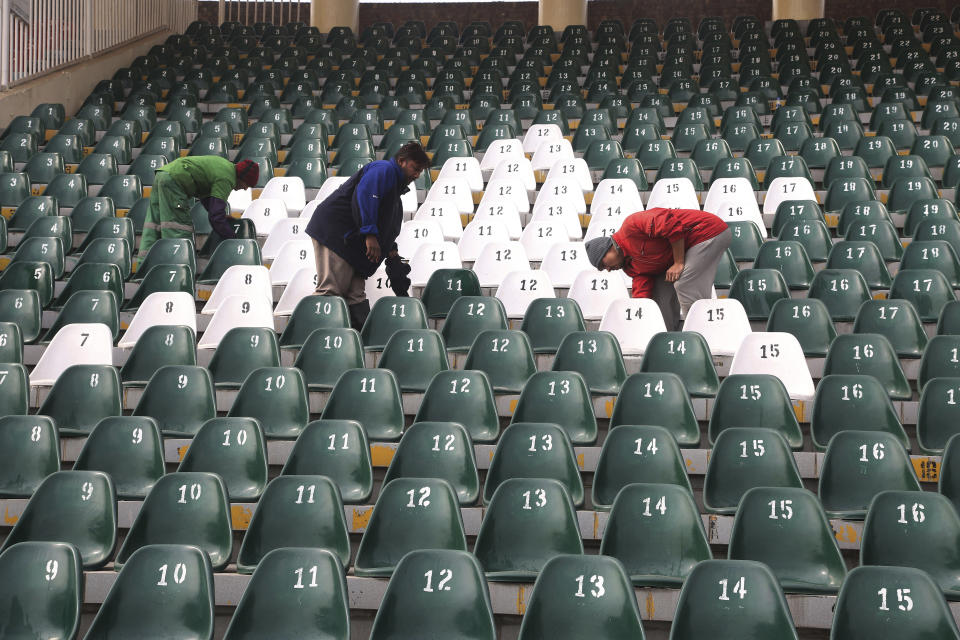 Workers clean an enclosure at Gaddafi stadium as preparation for the upcoming series against Bangladesh in Lahore, Pakistan, Tuesday, Jan. 21, 2020. Pakistan will play three Twenty20 series against Bangladesh, starting from Jan. 24, at Lahore. (AP Photo/K.M. Chaudary)