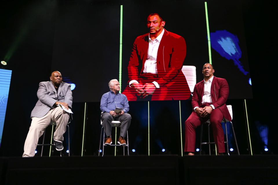 Guest speaker Tyrone Crawford, a former Dallas Cowboy, speaks to American-Statesman columnists Cedric Golden, left, and Kirk Bohls at the Austin High School Sports Awards ceremony Monday night.