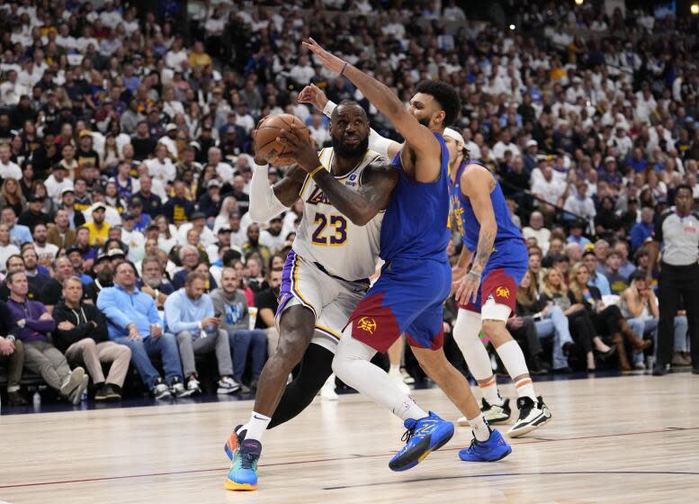 Lakers forward LeBron James drives to the basket against Nuggets guard Jamal Murray during their playoff game Saturday