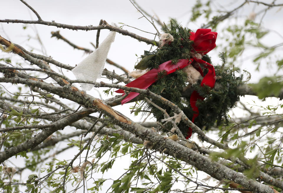 A wreath hangs in a tree along with storm debris along Seely Drive outside of Hamilton, Miss. after a storm moved through Sunday, April 14, 2019. (AP Photo/Jim Lytle)