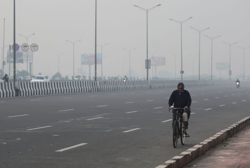 A man rides a cycle amidst the morning smog in New Delhi