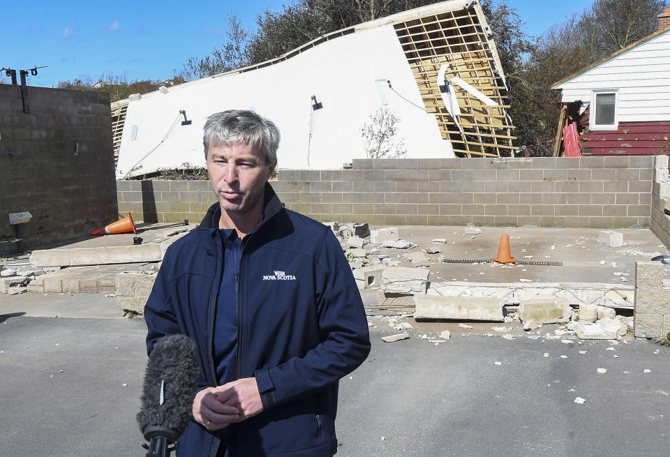 Nova Scotia Premier Tim Houston provides a briefing on post-tropical storm Fiona and the government response in front of a destroyed structure in Glace Bay, Nova Scotia, on Sunday, Sept. 25, 2022. A day after post-tropical storm Fiona left a trail of destruction through Atlantic Canada and eastern Quebec, residents of a coastal town in western Newfoundland continued to pick through wreckage strewn across their community, easily the most damaged area in the region. (Vaughan Merchant/The Canadian Press via AP)