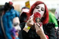 <p>A participant checks their costume before taking part in a in a zombie walk on World Zombie Day in London on Oct. 7, 2017. (Photo: Tolga Akmen/AFP/Getty Images) </p>