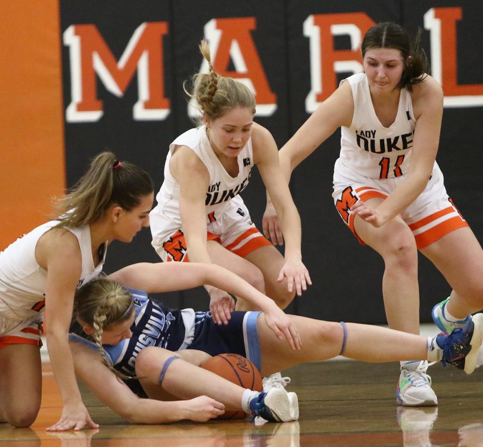 Marlington's, from left, Zoey Mort, Maria Warner and Chelsea Evanich and Louisville's Brooke Haren scramble for a loose ball during action Saturday afternoon at Marlington High School, January 28, 2023.