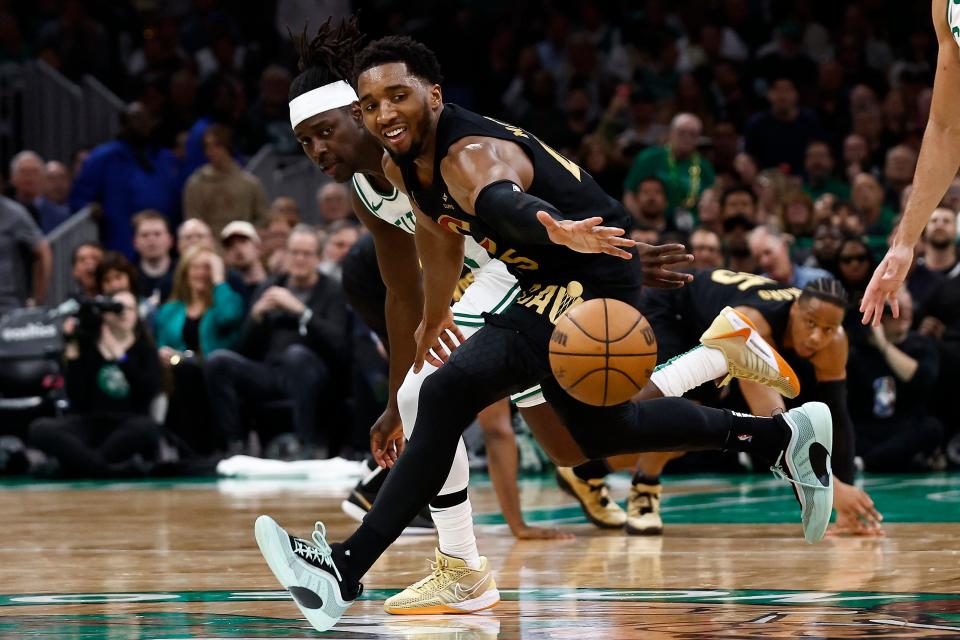 May 7, 2024; Boston, Massachusetts, USA; Cleveland Cavaliers guard Donovan Mitchell (45) reaches for a loose ball as Boston Celtics guard Jrue Holiday (4) looks on during the second quarter of game one of the second round of the 2024 NBA playoffs at TD Garden. Mandatory Credit: Winslow Townson-USA TODAY Sports