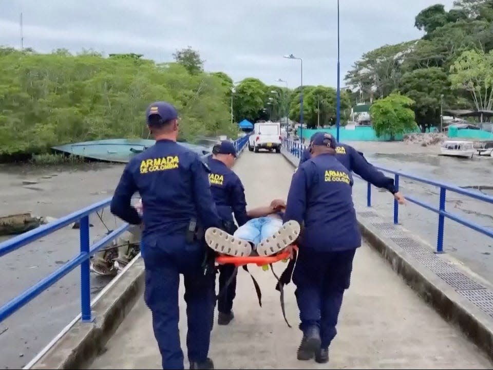 Colombian navy officers carry an injured person who was aboard the submarine on a stretcher.