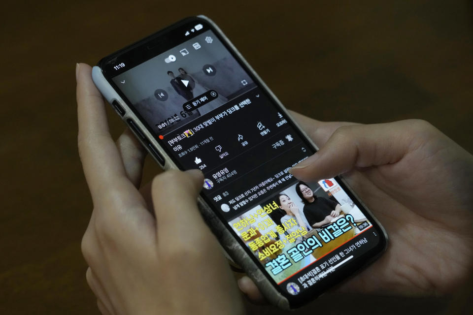 Yoo Young Yi holds her smartphone showing her and her husband Jo Jun Hwi's YouTube channel at their house in Seoul, South Korea, Sunday, Oct. 2, 2022. Many young people in South Korea have chosen not to marry or have children, citing a change of views toward a marriage and family life and uncertainty of their future. (AP Photo/Ahn Young-joon)