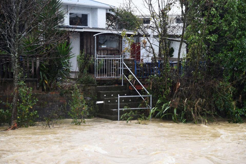 Water from the Maitai river is seen leading up to stairs of a property (AFP via Getty)