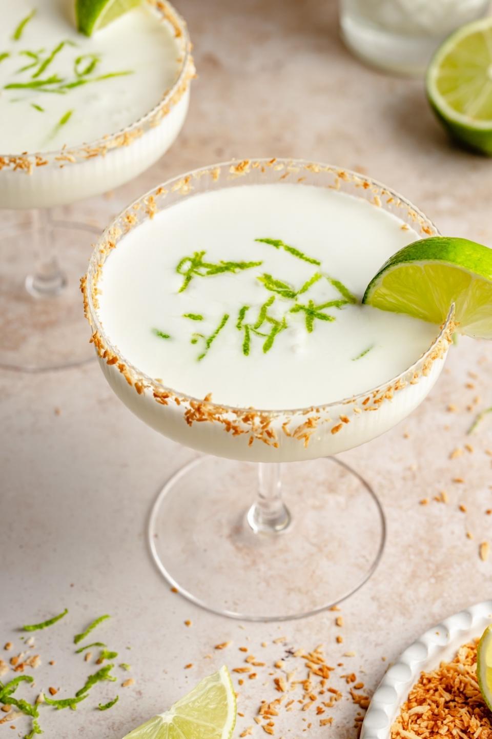 A coconut lime margarita in a coupe glass