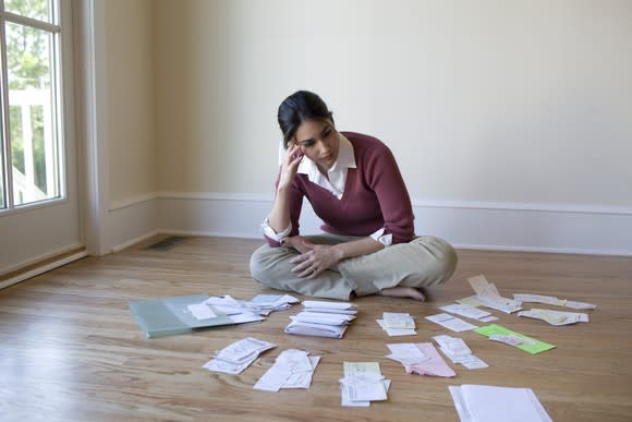 Woman with receipts and paperwork spread out on the floor