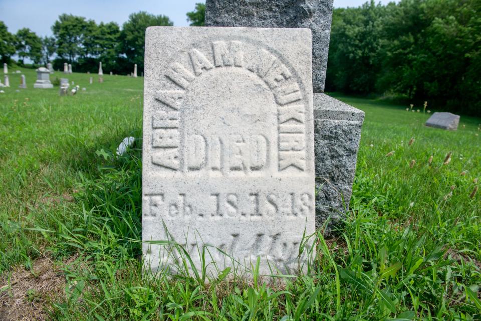 The gravemarker of Abraham Nieukirk rests against the large gravestone of his son McHenry Nieukirk in Haines Cemetery in Pekin.