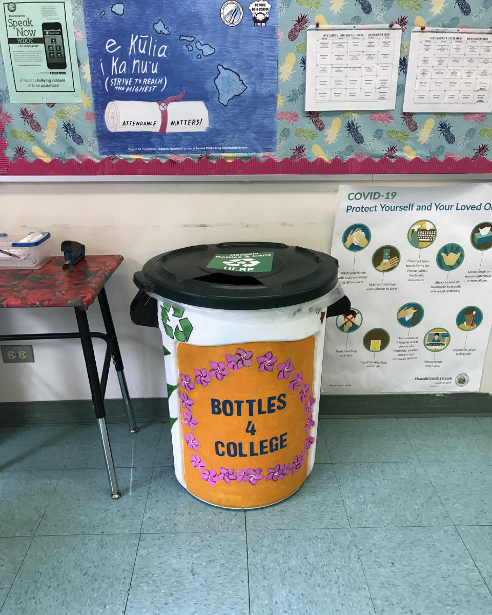 In this Oct. 10, 2020, photo provided by Maria Price, a student-painted drop-off bin for Genshu Price's fundraiser, Bottles4College, is stationed in the office at S.W. King Intermediate School in Kāne'ohe, Hawaii. Price started Bottles4College three years ago to raise money for his own tuition but has since expanded the recycling project to benefit other students. (Bottles4College via AP)