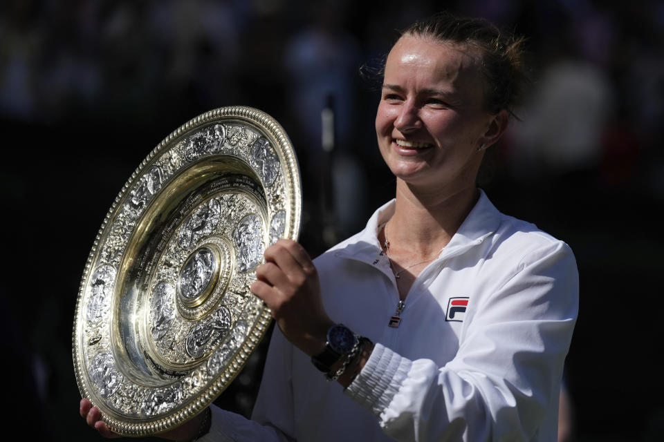 Barbora Krejcikova of the Czech Republic holds up the winners trophy for the photographers after she defeated Jasmine Paolini of Italy in the women's singles final at the Wimbledon tennis championships in London, Saturday, July 13, 2024. (AP Photo/Mosa'ab Elshamy)