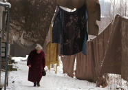 <p>A Bosnian Serb woman passes under blankets hung as an anti-sniper screen on Jan. 22, 1996, in the Sarajevo suburb of Grbavica. (Photo: Jacqueline Larma/AP) </p>