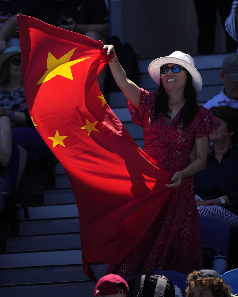 Supporters of China's Zhang Shuai wave her national flag during her fourth round match against Karolina Pliskova of the Czech Republic at the Australian Open tennis championship in Melbourne, Australia, Monday, Jan. 23, 2023. (AP Photo/Dita Alangkara)