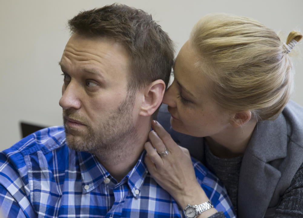 FILE - Russian opposition activist Alexei Navalny and his wife Yulia talk in a courtroom before the hearing in Moscow, Russia on April 23, 2015. Russia’s prison agency says that imprisoned opposition leader Alexei Navalny has died. He was 47. The Federal Prison Service said in a statement that Navalny felt unwell after a walk on Friday Feb. 16, 2024 and lost consciousness. (AP Photo/Pavel Golovkin, File)