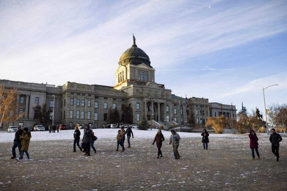 Staff evacuate from the Montana State Capitol, Wednesday morning, Jan. 3, 2023, after a bomb threat. (Thom Bridge/Independent Record via AP)