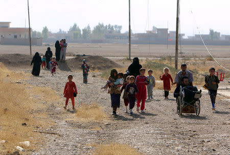 Iraqi displaced people walk after they escaped from the Islamic State-controlled village of Abu Jarboa, Iraq October 31, 2016. REUTERS/Azad Lashkari