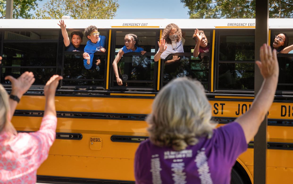 W. D. Hartley Elementary School teachers wave to students as they depart on the last day of school, Thursday, June 2, 2022.