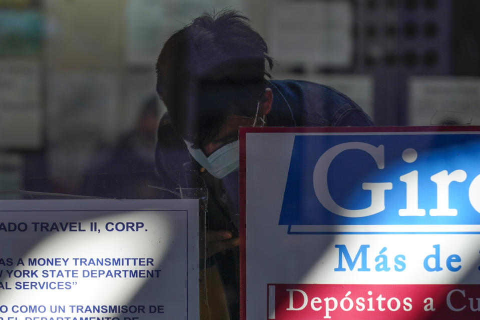 A man fills out forms at a money transfer business in the Queens borough of New York, Thursday, Oct. 6, 2022. Inflation isn't affecting people equally. For migrants with relatives relying on money they send back, higher prices are pinching families twice: at home and abroad. (AP Photo/Seth Wenig)