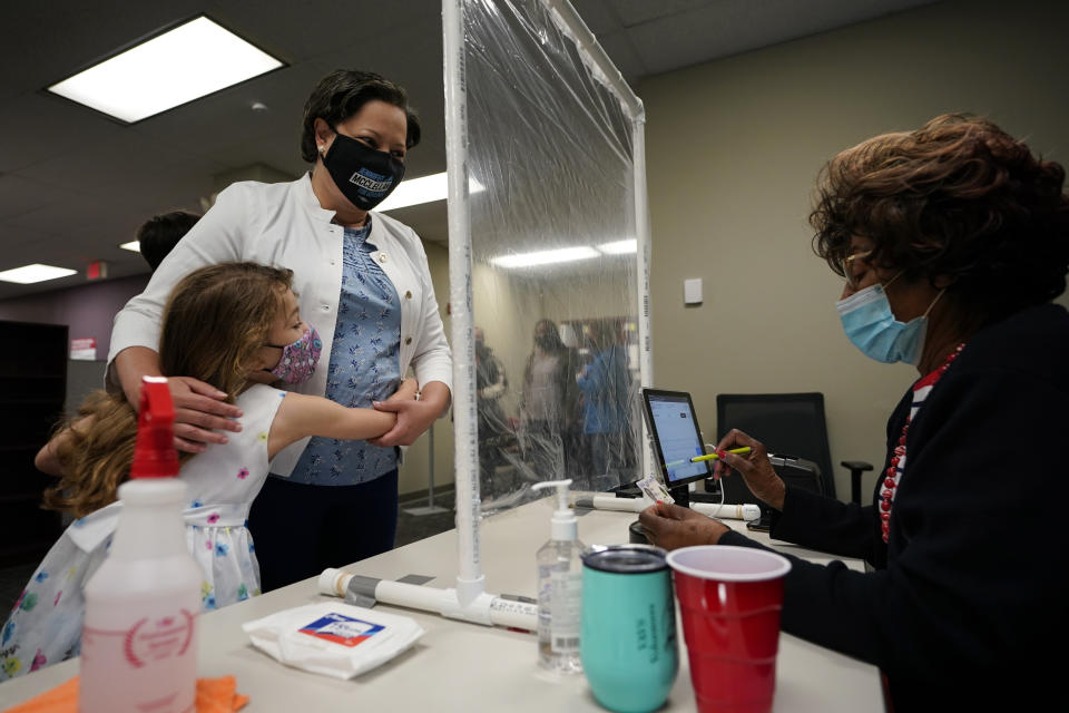 Democratic gubernatorial candidate, Virginia State Sen. Jennifer McClellan, top, gets a hug from her daughter Samantha, left, as she checks in at an early voting location in Richmond, Va., Saturday, May 29, 2021. McClellan faces four other Democrats in the primary Tuesday. (AP Photo/Steve Helber)